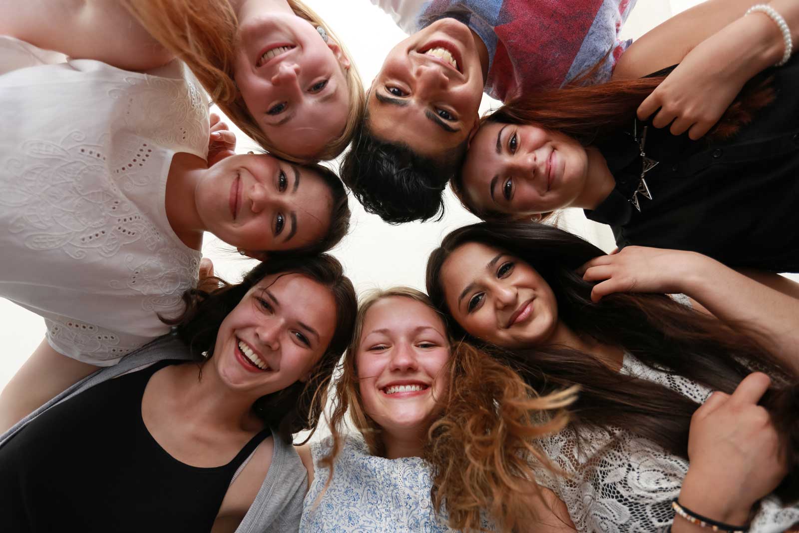 Ein Mädchen legt in einer Kirche den Arm auf die Schulter eines Freundes. 